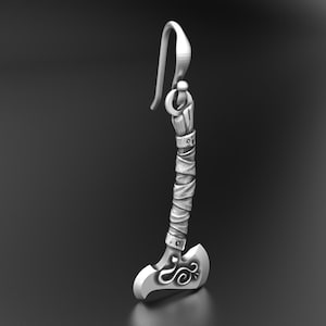 May include: A silver-toned metal earring shaped like a small battle axe. The handle features a wrapped texture, and the axe head is decorated with a delicate, swirling engraved pattern. The piece hangs from a simple, curved metal ear wire hook.