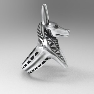 K&ouml;nnte beinhalten: Silberring mit einem Anubis-Kopfdesign. Der Ringband ist mit schwarzen Akzenten strukturiert.