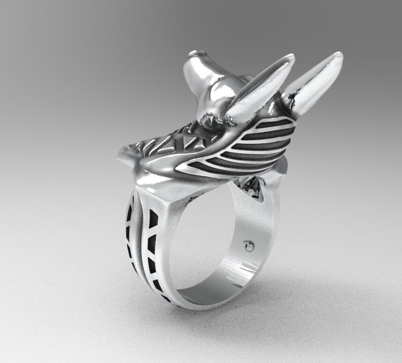 K&ouml;nnte beinhalten: Ein silberner Ring mit einem detaillierten Anubis-Kopfdesign. Der Ring ist aus Metall gefertigt und hat eine glatte, polierte Oberfl&auml;che.