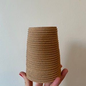 Small ribbed raw clay vase
