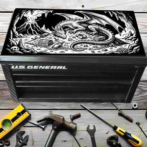 May include: Black tool chest with a dragon graphic on the lid. The dragon is white and black, surrounded by treasure and a volcanic landscape. The tool chest has the words "U.S. GENERAL" in white.
