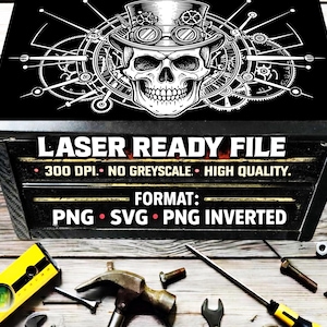 May include: A black box featuring a white graphic of a skull wearing a top hat with goggles and gears. Text reads: LASER READY FILE, 300 DPI, NO GREYSCALE, HIGH QUALITY, FORMAT: PNG, SVG, PNG INVERTED. Tools are visible on the surface below the box.