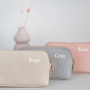 Die drei Farben der Kosmetiktasche nebeneinander stehend. (Beige, Grau, Rosa)