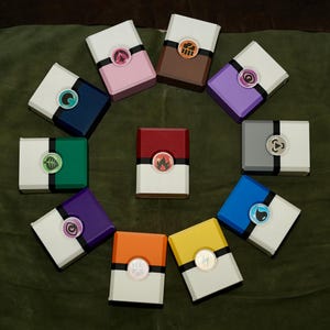 May include: A white ceramic mug with a black handle and the text "But First, Coffee" in a black, bold font. The mug is sitting on a wooden surface. The mug is 4 inches tall.