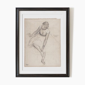 K&ouml;nnte beinhalten: Eine Schwarzwei&szlig;-Bleistiftzeichnung einer Ballerina in einem Tutu, die sitzt und ihren Schuh anpasst. Die Zeichnung befindet sich auf einem Blatt Papier mit einem Gittermuster. Die Unterschrift des K&uuml;nstlers befindet sich in der rechten unteren Ecke.