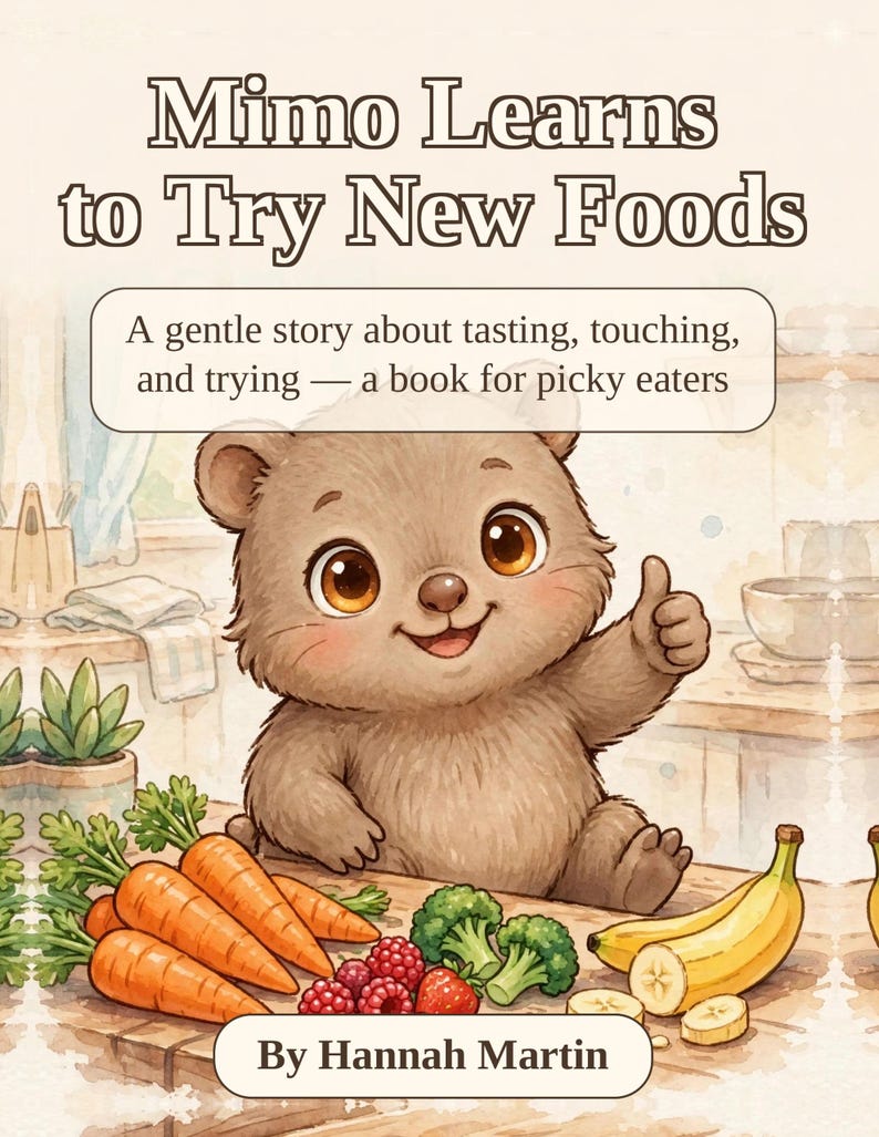 May include: A children's book titled Mimo Learns to Try New Foods by Hannah Martin. The cover features a brown bear cub giving a thumbs up, surrounded by carrots, raspberries, broccoli, and bananas on a wooden table in a kitchen setting.