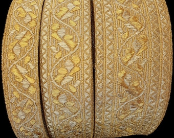 May include: Three rolls of gold and white trim with a geometric pattern. The trim is woven with a raised design.