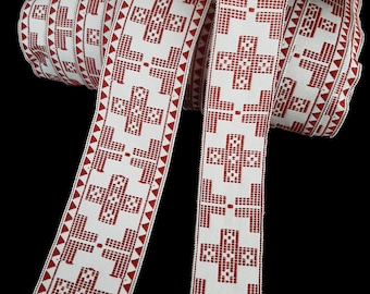 May include: Red and white woven ribbon with a repeating cross pattern. The ribbon is folded and stacked, showing the pattern from different angles.