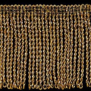 May include: Gold metallic fringe trim with a twisted rope design. The fringe is approximately 2.5 cm long.