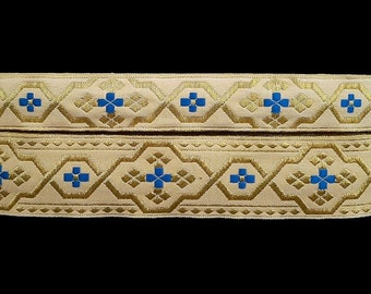 May include: Two beige fabric trims with gold and blue geometric patterns. The trim has a repeating pattern of blue squares with gold accents.