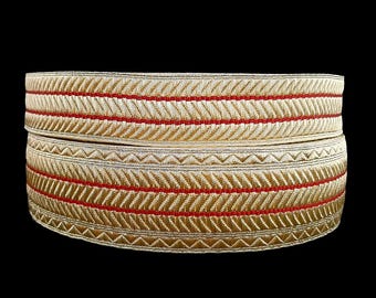 May include: Two rolls of gold and red trim with a chevron pattern. The trim is made of a woven fabric and has a subtle sheen.