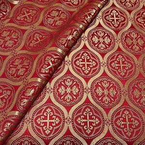 Peut inclure: Un tissu rouge profond présentant un motif tissé répétitif de médaillons circulaires dorés. Chaque médaillon contient un motif de croix stylisée avec des détails floraux complexes. Le tissu est plié, révélant la texture des fils dorés.