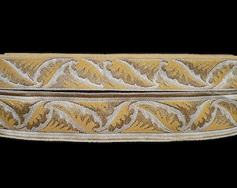 May include: Two rolls of gold and white trim with a leaf pattern. The trim is woven and has a subtle sheen.