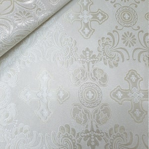 May include: White fabric with a raised embossed pattern of crosses and floral designs.