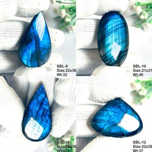 Pu&ograve; includere: Quattro pietre preziose di labradorite levigate con vibrante iridescenza blu. SBL-9 misura 22x36mm a 32ct, SBL-10 21x37mm a 40ct, SBL-11 20x38mm a 42ct e SBL-12 22x30mm a 37ct. Ogni pietra mostra fratture interne uniche.