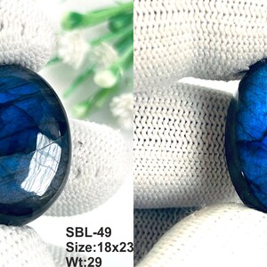 Pu&ograve; includere: Due pietre preziose di labradorite di forma ovale con un profondo riflesso blu iridescente. La pietra a sinistra &egrave; etichettata SBL-49, dimensioni 18x23, peso 29. La pietra a destra &egrave; etichettata SBL-50, dimensioni 15x24, peso 20. Superficie liscia.
