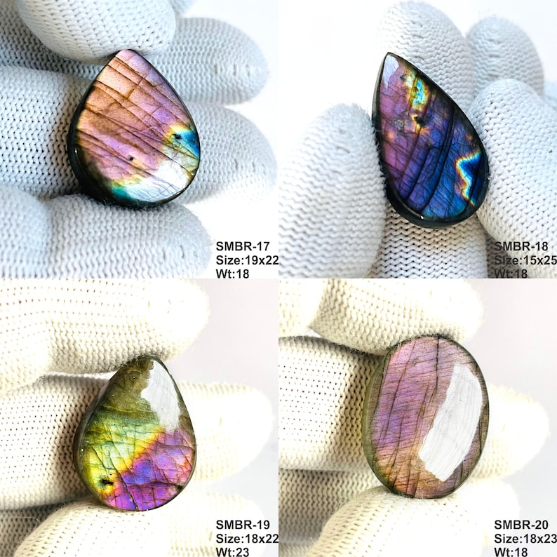May include: Four polished labradorite gemstones in teardrop and oval shapes. The stones display iridescent colors of purple, blue, and green. Each stone has a unique pattern and is set against a white background. The text "SMBR-17 Size:19x22 Wt:18", "SMBR-18 Size:15x25 Wt:18", "SMBR-19 Size:18x22 Wt:23", and "SMBR-20 Size:18x23 Wt:18" is visible.