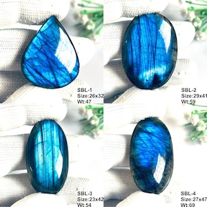Pu&ograve; includere: Quattro pietre preziose di labradorite lucidate con iridescenza blu. SBL-1: 26x32mm, 47ct. SBL-2: 29x41mm, 59ct. SBL-3: 23x42mm, 54ct. SBL-4: 27x47mm, 69ct. Ogni pietra mostra un motivo di frattura interna unico e una superficie liscia.