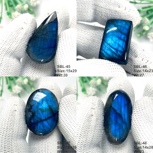 Pu&ograve; includere: Quattro pietre preziose di labradorite lucida con vibrante iridescenza blu. Le pietre sono etichettate SBL-45 (15x29, 30), SBL-46 (14x23, 27), SBL-47 (18x26, 24) e SBL-48 (14x28, 23). Ogni pietra mostra una forma unica, tra cui a goccia, rettangolare e ovale.