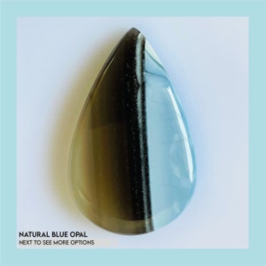 Puede incluir: Una piedra preciosa de ópalo azul natural en forma de lágrima. La piedra está dividida verticalmente, con un lado marrón oscuro y el otro azul claro. El texto "NATURAL BLUE OPAL NEXT TO SEE MORE OPTIONS" está en la parte inferior.