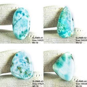 May include: Four polished larimar gemstones with marbled patterns of sky blue, turquoise, and white. Each stone is labeled with text: SLRMR-41 Size:14X25 Wt:19, SLRMR-42 Size:14X25 Wt:18, SLRMR-43 Size:17X21 Wt:19, and SLRMR-44 Size:18X20 Wt:18.