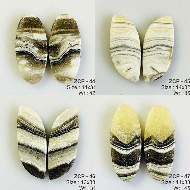 May include: Four pairs of polished gemstone cabochons. Each pair has a unique pattern of beige, brown, and black swirls. The text on the image indicates sizes ranging from 13x33 mm to 14x33 mm.