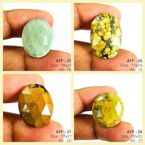 May include: Four faceted gemstones in oval shapes. The gemstones are in shades of green, yellow, and brown. The text "ATF - 25 Size: 16x21 Wt: 16", "ATF - 26 Size: 17x25 Wt: 15", "ATF - 27 Size: 17x21 Wt: 20", and "ATF - 28 Size: 20x22 Wt: 21" are visible.