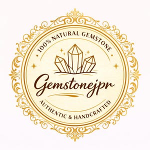 May include: A circular gold logo featuring an ornate filigree border. In the center, three crystal illustrations sit above the text Gemstonejpr. The text 100% NATURAL GEMSTONE appears at the top, and AUTHENTIC & HANDCRAFTED is printed at the bottom.