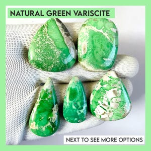 May include: Five polished natural green variscite gemstones with white and gray veining. The stones are various shapes, including teardrop and oval. The text "NATURAL GREEN VARISCITE" and "NEXT TO SEE MORE OPTIONS" are visible.