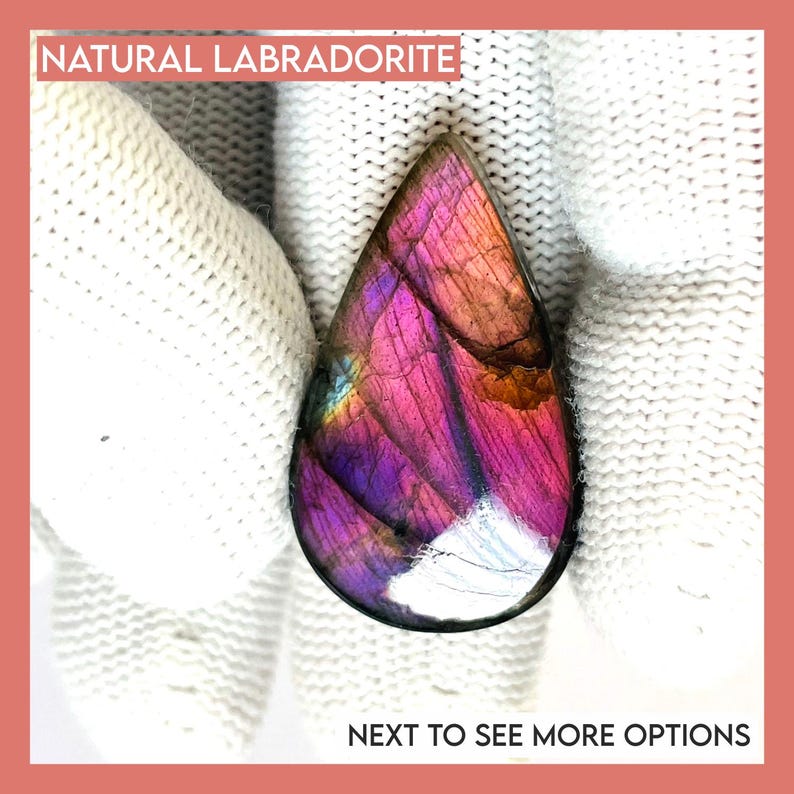 May include: A teardrop-shaped natural labradorite gemstone with vibrant purple, pink, and orange hues. The stone is held against a white knitted background. Text at the top reads "NATURAL LABRADORITE" and at the bottom "NEXT TO SEE MORE OPTIONS".