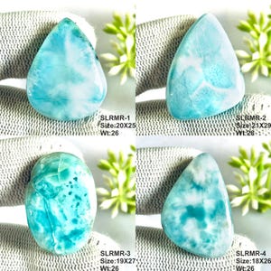May include: Four polished Larimar cabochons with blue and white marbled patterns. Top left: SLRMR-1, 20x25mm, 26ct. Top right: SLRMR-2, 21x29mm, 28ct. Bottom left: SLRMR-3, 19x27mm, 26ct. Bottom right: SLRMR-4, 18x26mm, 26ct. Each stone is smooth.