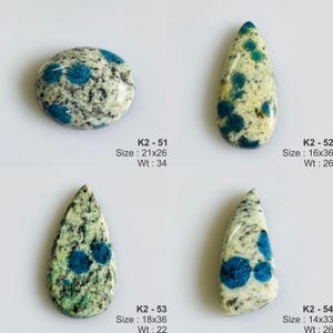 May include: Four K2 granite cabochons with blue azurite spots. K2-51 is oval, 21x26, 34. K2-52 is teardrop, 16x36, 26. K2-53 is teardrop, 18x36, 22. K2-54 is teardrop, 14x33, 26. Each stone features a white and black speckled base.