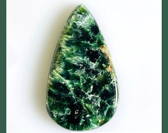 May include: A teardrop-shaped natural seraphinite gemstone featuring deep forest green hues with intricate, feathery white and silver chatoyant patterns throughout the surface. The text NATURAL SERAPHINITE and Next to see more options are visible.