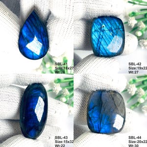 Pu&ograve; includere: Quattro pietre preziose di labradorite lucidate con riflessi blu iridescenti. SBL-41 &egrave; una goccia 16x27, SBL-42 un quadrato 19x22, SBL-43 un ovale 15x32 e SBL-44 un quadrato 20x22. Ogni pietra mostra fratture interne uniche e toni blu.