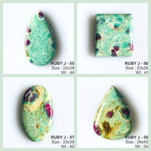 May include: Four polished cabochon gemstones featuring a mix of green and teal matrix with embedded magenta ruby inclusions. Each stone is labelled with a code, size in mm, and weight in carats: Ruby J-55 (22x38mm, 44ct), J-56 (23x26mm, 41ct), J-57 (23x39mm, 45ct), and J-58 (26x45mm, 54ct).