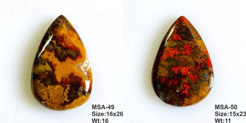 K&ouml;nnte beinhalten: Zwei polierte, birnenf&ouml;rmige Cabochons mit komplexen Mustern in Braun, Orange und Rot. Der linke Stein ist mit MSA-49, Gr&ouml;&szlig;e 16x26, Gewicht 16 beschriftet. Der rechte Stein mit MSA-50, Gr&ouml;&szlig;e 15x23, Gewicht 11. Beide haben glatte, gl&auml;nzende Oberfl&auml;chen.