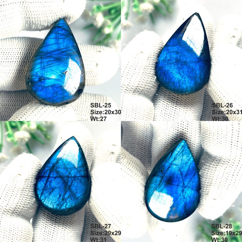 Pu&ograve; includere: Quattro pietre preziose di labradorite a forma di goccia con riflessi blu iridescenti e venature scure. Ogni pietra &egrave; etichettata con i codici SBL-25, SBL-26, SBL-27 e SBL-28, incluse dimensioni in mm e peso in carati, come 20x30 mm e 27 ct.