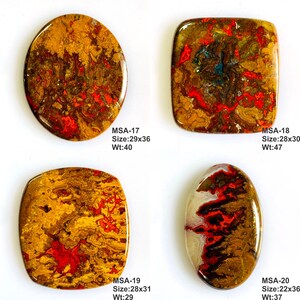 K&ouml;nnte beinhalten: Vier polierte Cabochon-Edelsteine mit wirbelnden Mustern in Braun, Gold und leuchtendem Rot. Jeder Stein ist mit den Codes MSA-17, MSA-18, MSA-19 und MSA-20 beschriftet, einschlie&szlig;lich der Abmessungen in mm und des Gewichts in Karat.