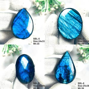 Pu&ograve; includere: Quattro pietre preziose di labradorite lucidate a forma di goccia e ovale, che mostrano una vibrante iridescenza blu. Ogni pietra &egrave; etichettata con i codici SBL-5, SBL-6, SBL-7 e SBL-8, incluse dimensioni in mm e pesi in carati, come 24x33 mm e 35 ct.