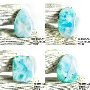 May include: Four polished Larimar gemstones in teardrop, oval, and rectangular shapes. Each stone displays a marbled pattern of sky blue and white. Text labels include codes like SLRMR-37, sizes in mm, and weights in carats for each individual piece.