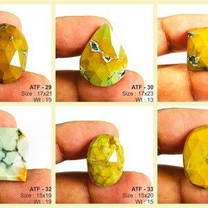 May include: Six faceted gemstones in shades of yellow, green, and white are displayed. Each stone has a unique shape, including oval, teardrop, and rectangular cuts. The sizes range from 15x18 to 17x23, and the weights vary from 11 to 19. The text "ATF" and numbers are visible.
