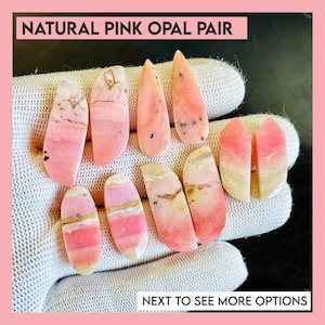 May include: A collection of natural pink opal pairs, displayed on a white glove. The opals vary in shape and feature shades of pink, white, and gold. The text "NATURAL PINK OPAL PAIR" and "NEXT TO SEE MORE OPTIONS" are visible.