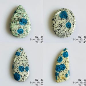 May include: Four K2 stone cabochons with blue azurite spots on granite. K2-47 is a 26x35mm teardrop, K2-48 is a 23x30mm oval, K2-49 is a 17x37mm teardrop, and K2-50 is a 16x43mm elongated shape. Weights are 38, 40, 23, and 27 units respectively.