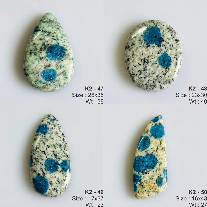 May include: Four K2 stone cabochons with blue azurite spots on granite. K2-47 is a 26x35mm teardrop, K2-48 is a 23x30mm oval, K2-49 is a 17x37mm teardrop, and K2-50 is a 16x43mm elongated shape. Weights are 38, 40, 23, and 27 units respectively.