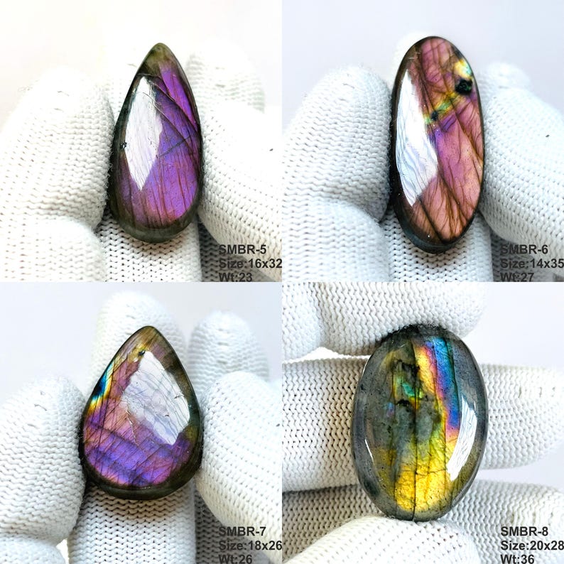 May include: Four polished labradorite gemstones in various shapes. One is teardrop-shaped, others are oval. The stones display iridescent flashes of purple, blue, and gold. The text on the image indicates sizes and weights in millimeters and grams.