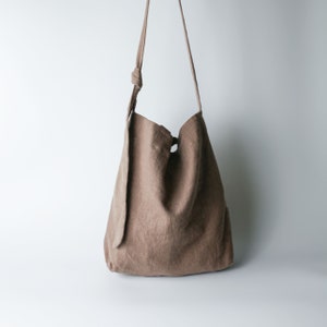 Urban French natural linen hobo crossbody bag featuring top handles, an internal zip pocket and an adjustable shoulder strap Brown