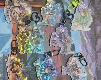 May include: A set of ten holographic keychains featuring characters from the video game Nier Automata. The keychains are made of clear acrylic and feature a variety of characters, including 2B, 9S, A2, and Pod 153. The keychains are all different sizes and shapes, and they are all very detailed.