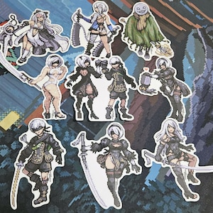 May include: A set of ten stickers featuring various characters from the video game Nier Automata. The stickers are printed on a white background and feature a variety of poses and expressions. The characters include 2B, 9S, A2, and Pod 153.