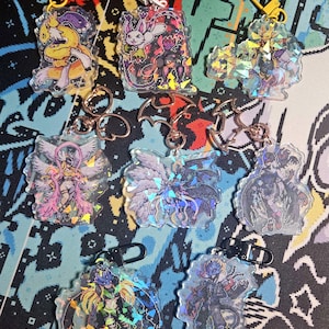 Può includere: Un set di dieci portachiavi olografici con vari personaggi anime. I portachiavi sono realizzati in acrilico trasparente e hanno una finitura arcobaleno iridescente. Ogni portachiavi presenta un personaggio diverso della serie anime, tra cui un angelo alato, un demone e un drago.