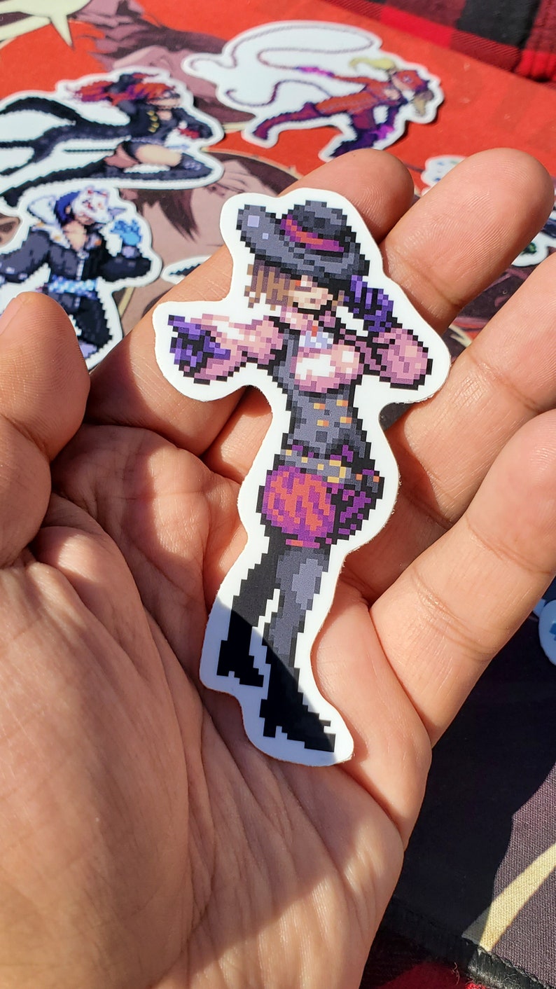Pode incluir: Um adesivo de pixel art de uma personagem feminina vestindo uma roupa roxa e preta com um chap&eacute;u. A personagem est&aacute; segurando uma arma e tem uma express&atilde;o determinada no rosto.